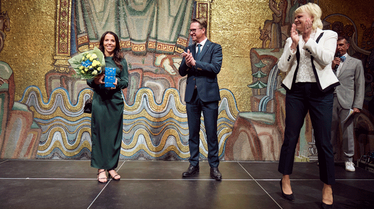 Sveriges mest framgångsrika kvinnliga olympier, Charlotte Kalla, prisades av SOK:s styrelse i form av Mats Årjes och Anette Norberg. Foto: SOK.