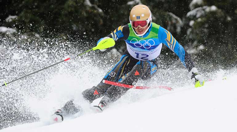 Slalomåkaren André Myhrer fångad i farten när han svänger runt en käpp så att snön sprutar. 