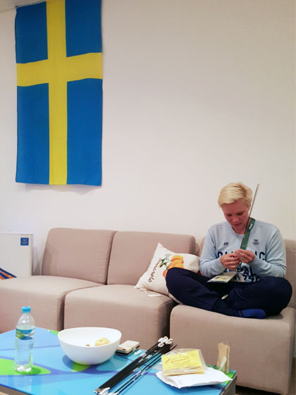 Christine Bjerendahl ordnar med sina pilar dagen före tävling i Svenskhusets vardagsrum i OS-byn. Foto: SOK