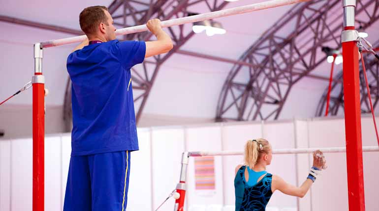 Coach Sebastian Melander och gymnasten Jonna Adlerteg preparerar barren inför ett träningspass i London 2012. Foto: SOK
