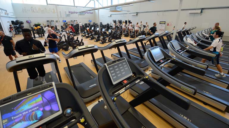 Ett stort gym med massor av löpmaskiner och annan träningsutrustning. 